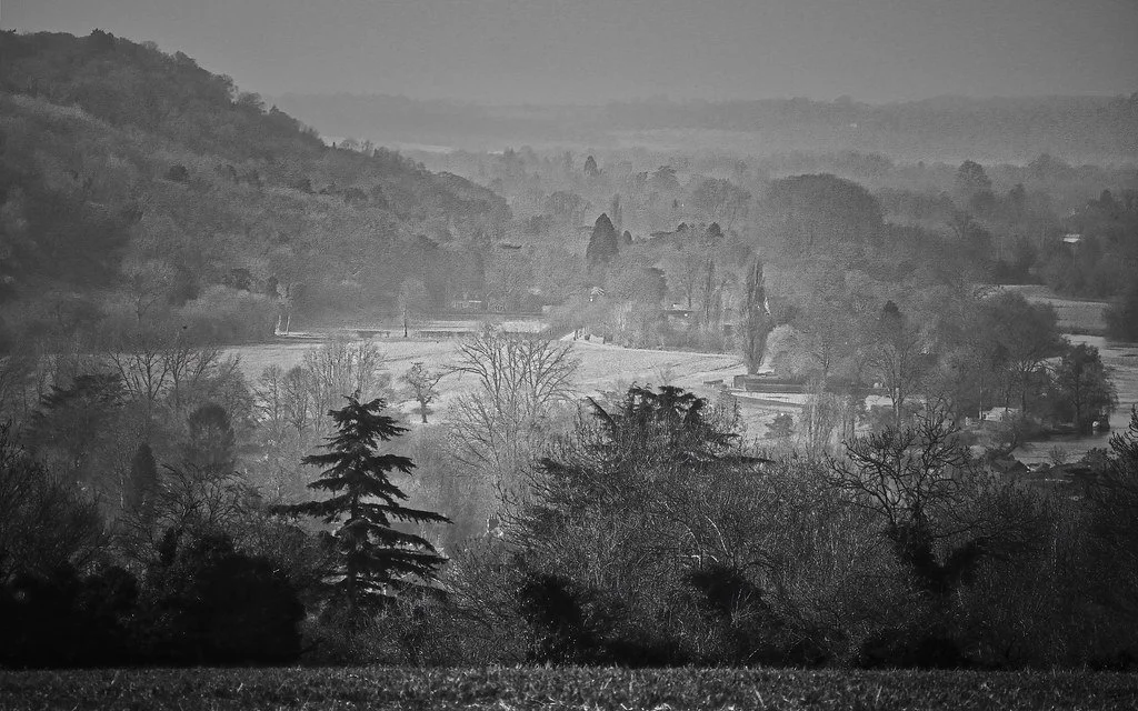 Misty autumn landscape across the Thames Valley and Chiltern Hills photographed in black and white