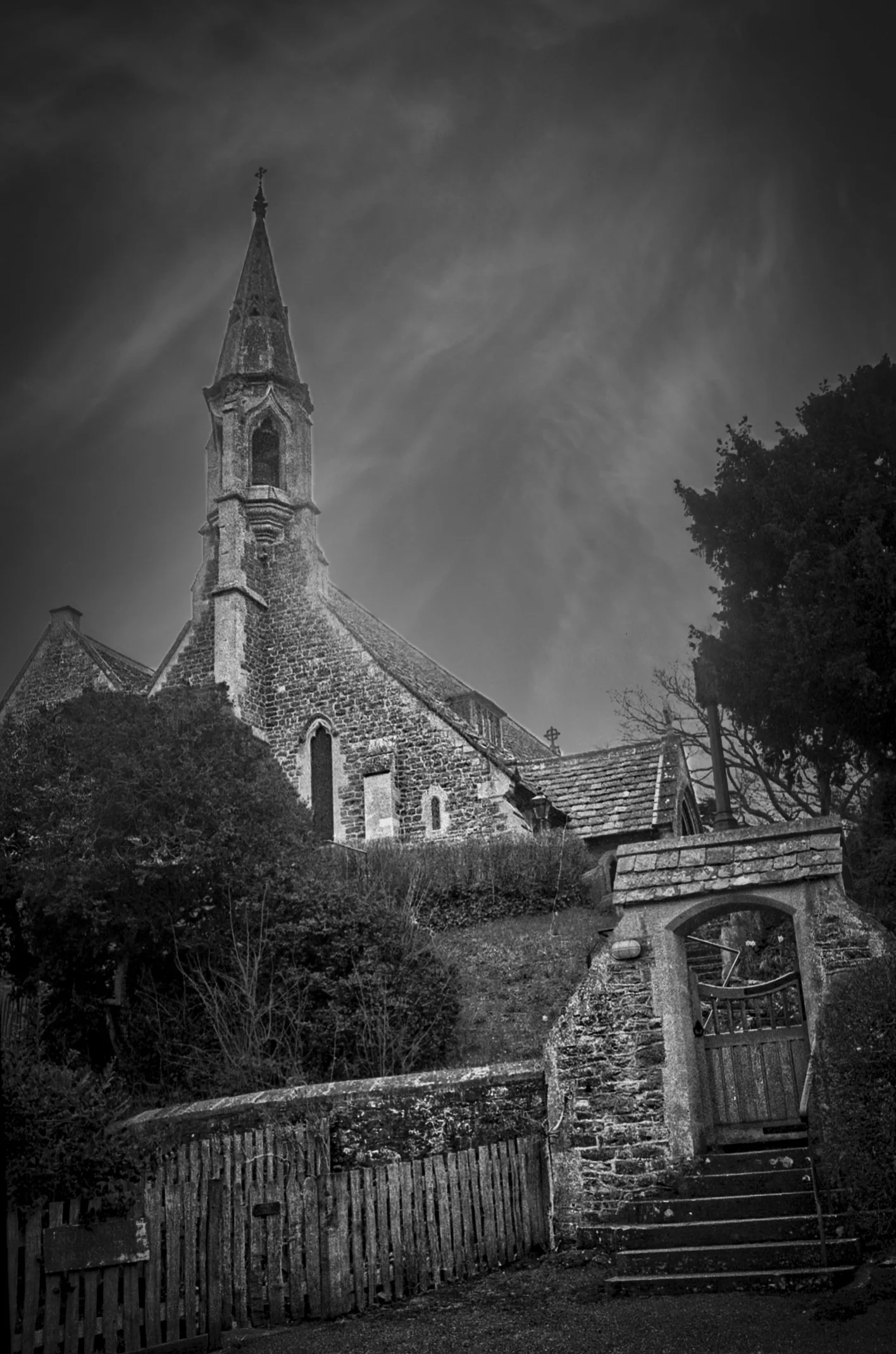 Historic church with stone gateway photographed in black and white