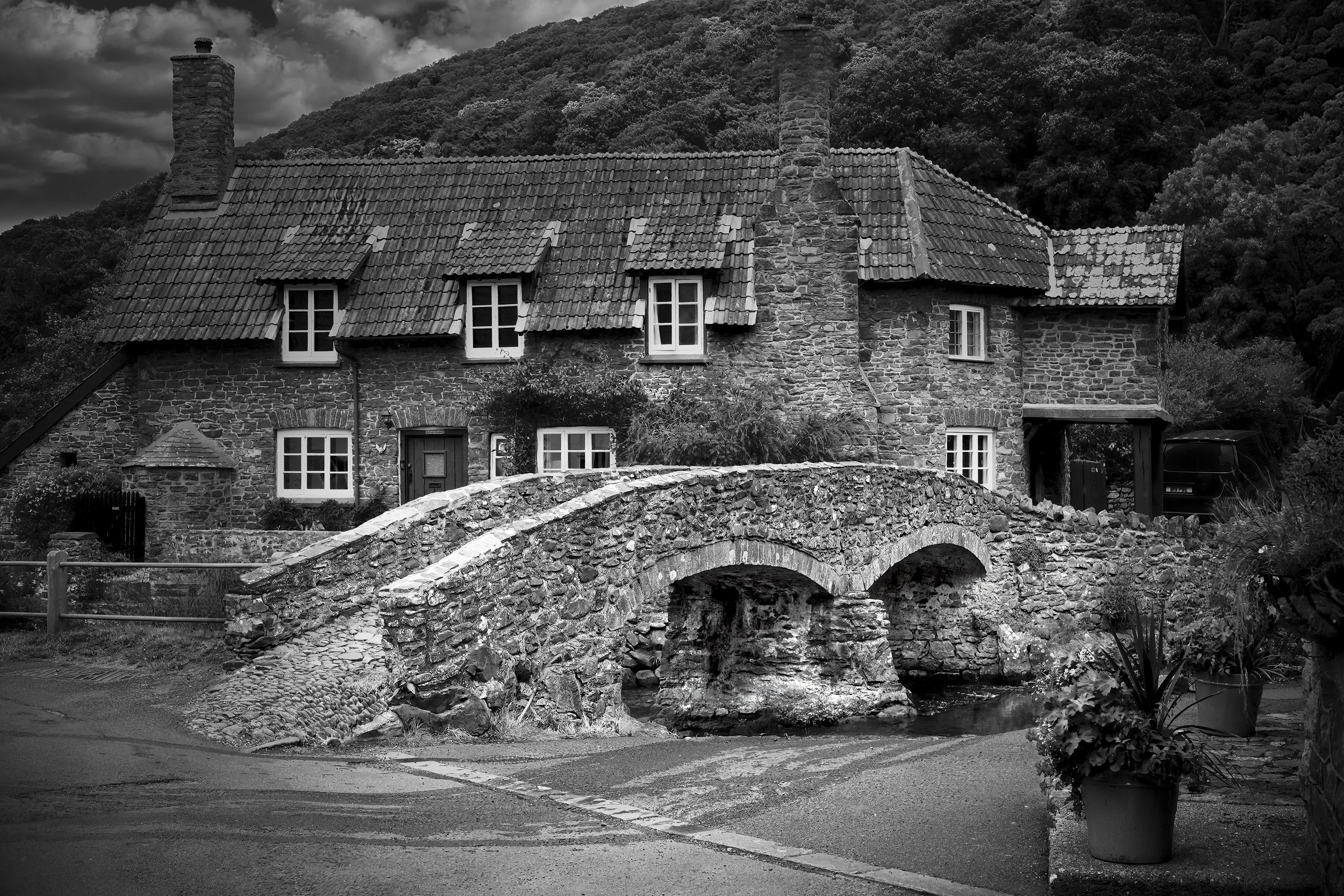 Historic stone property and bridge photographed in black and white