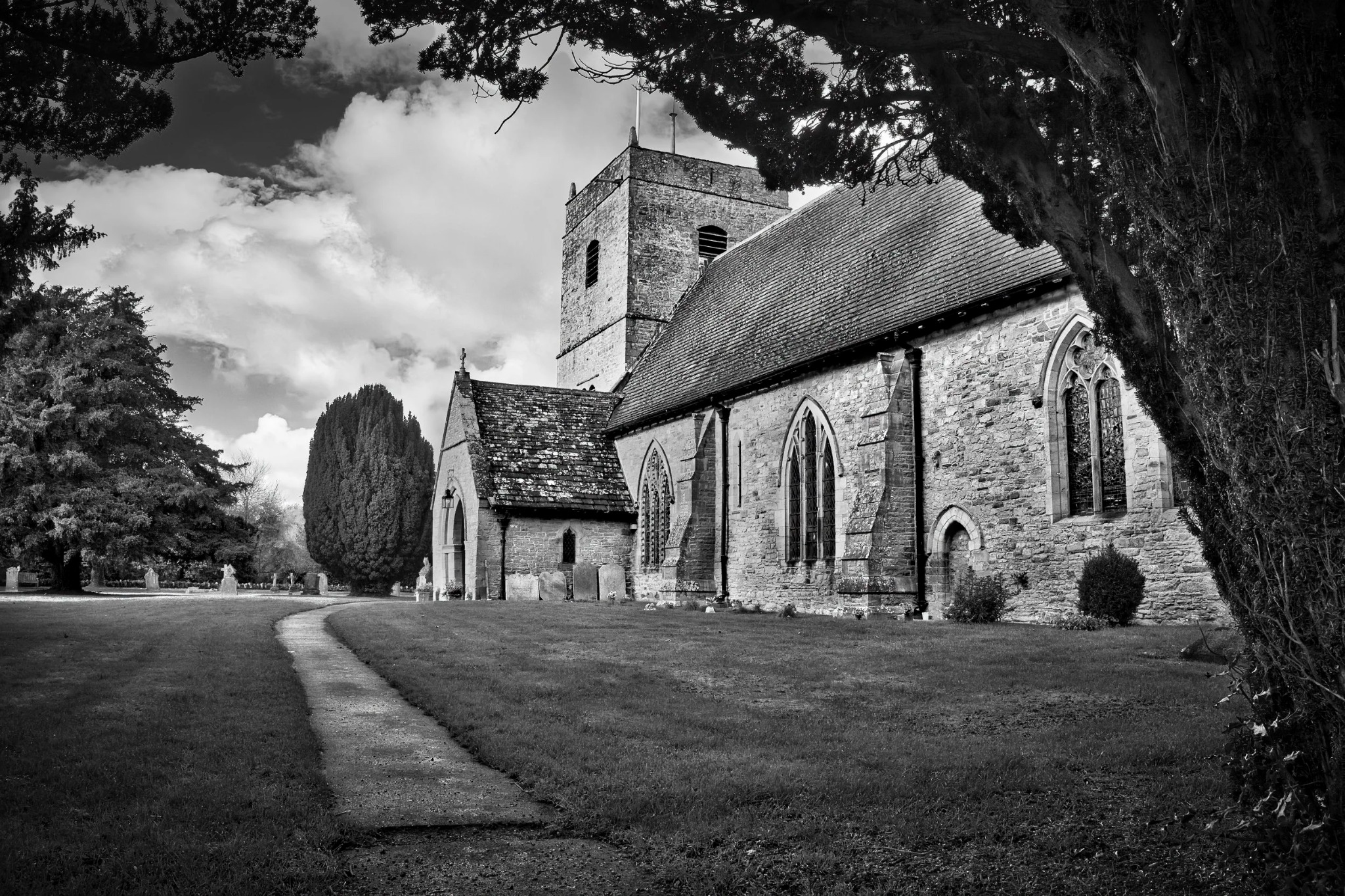 Village church and graveyard beneath a dramatic sky