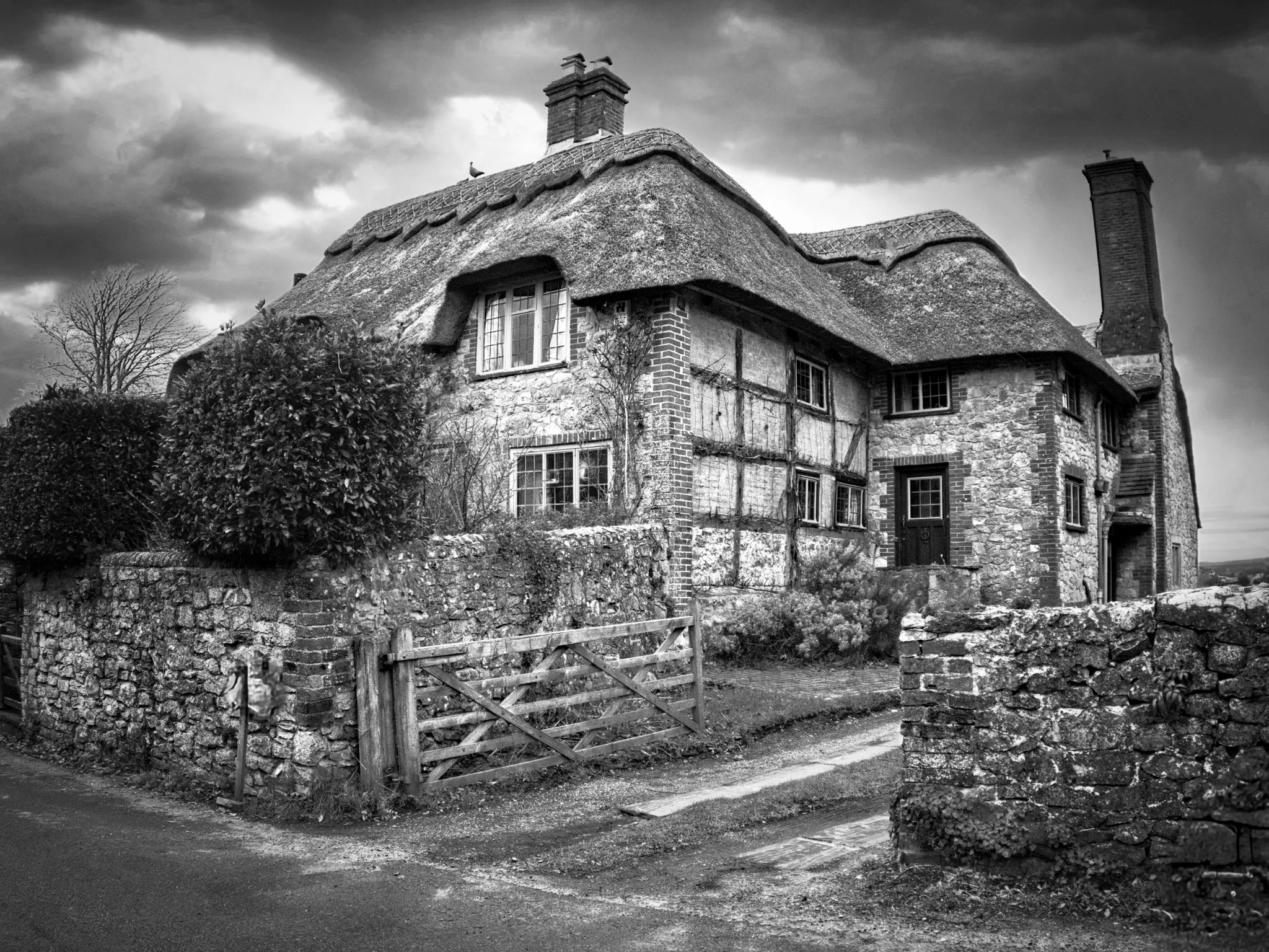 Thatched country cottage beneath a dramatic sky
