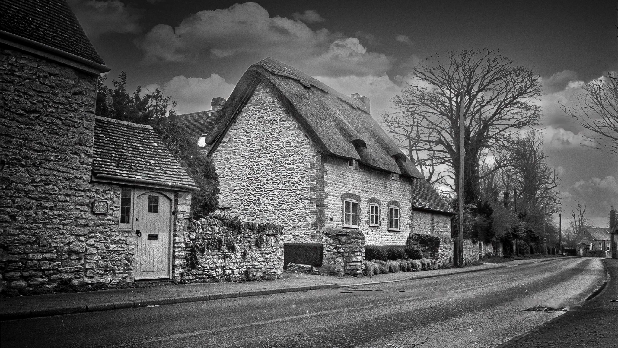 Traditional thatched cottage beside a village road
