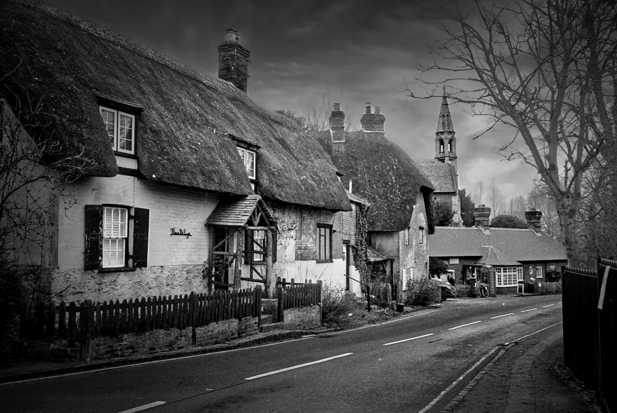 Thatched cottages with church spire in a rural village