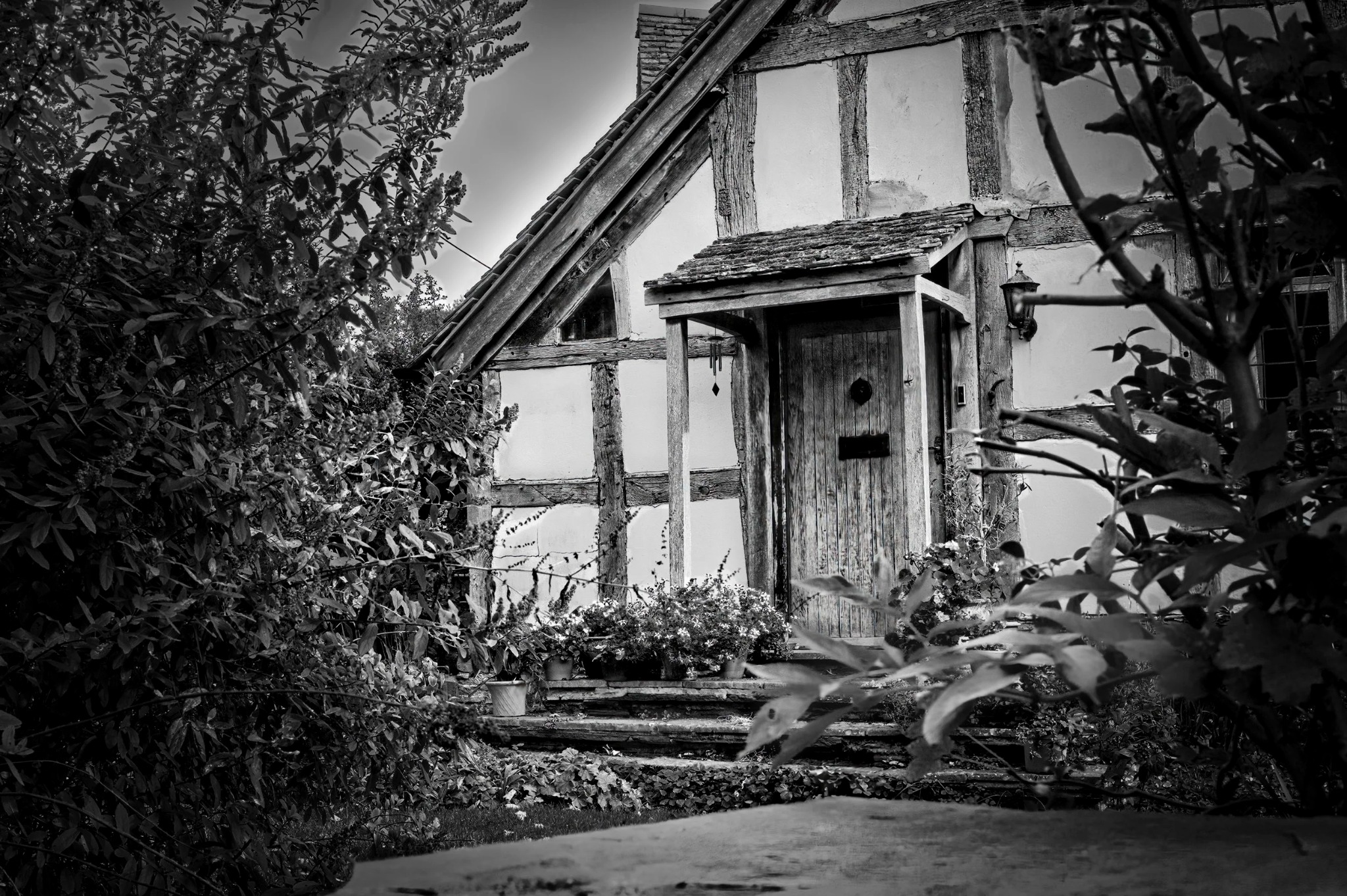 Old hand water pump and barrel beside a cottage