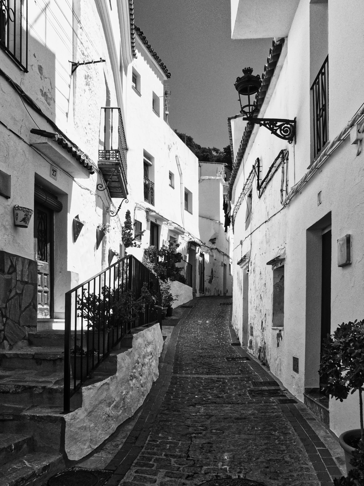 Narrow village alley ornate lamp plants andalusia