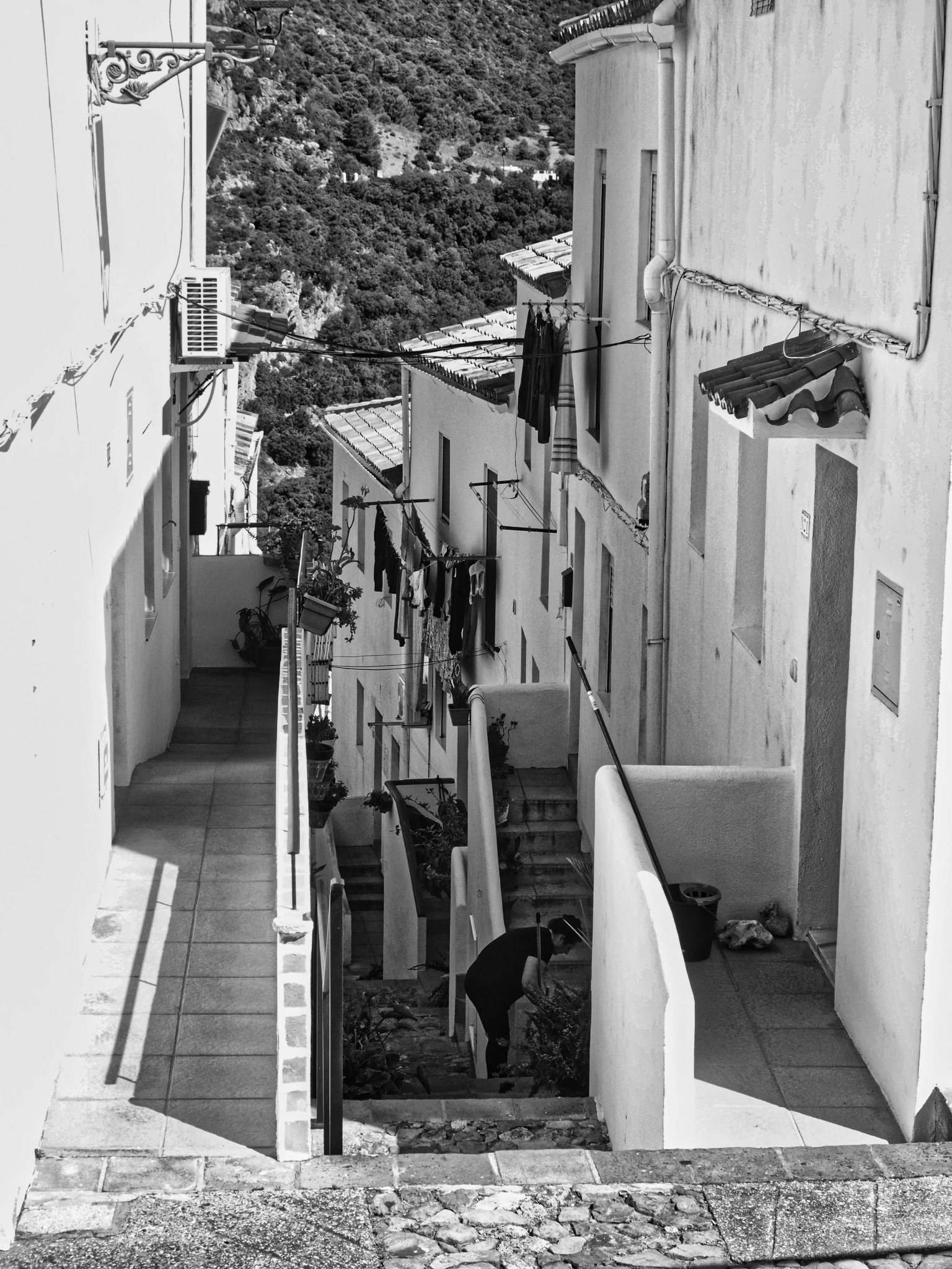 Steep alley laundry woman sweeping hillside andalusia