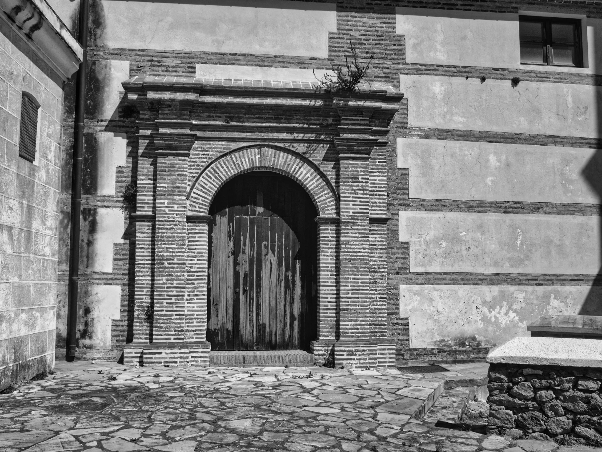 Pconvent doorway brick arch wooden doors flagstones andalusia5300197