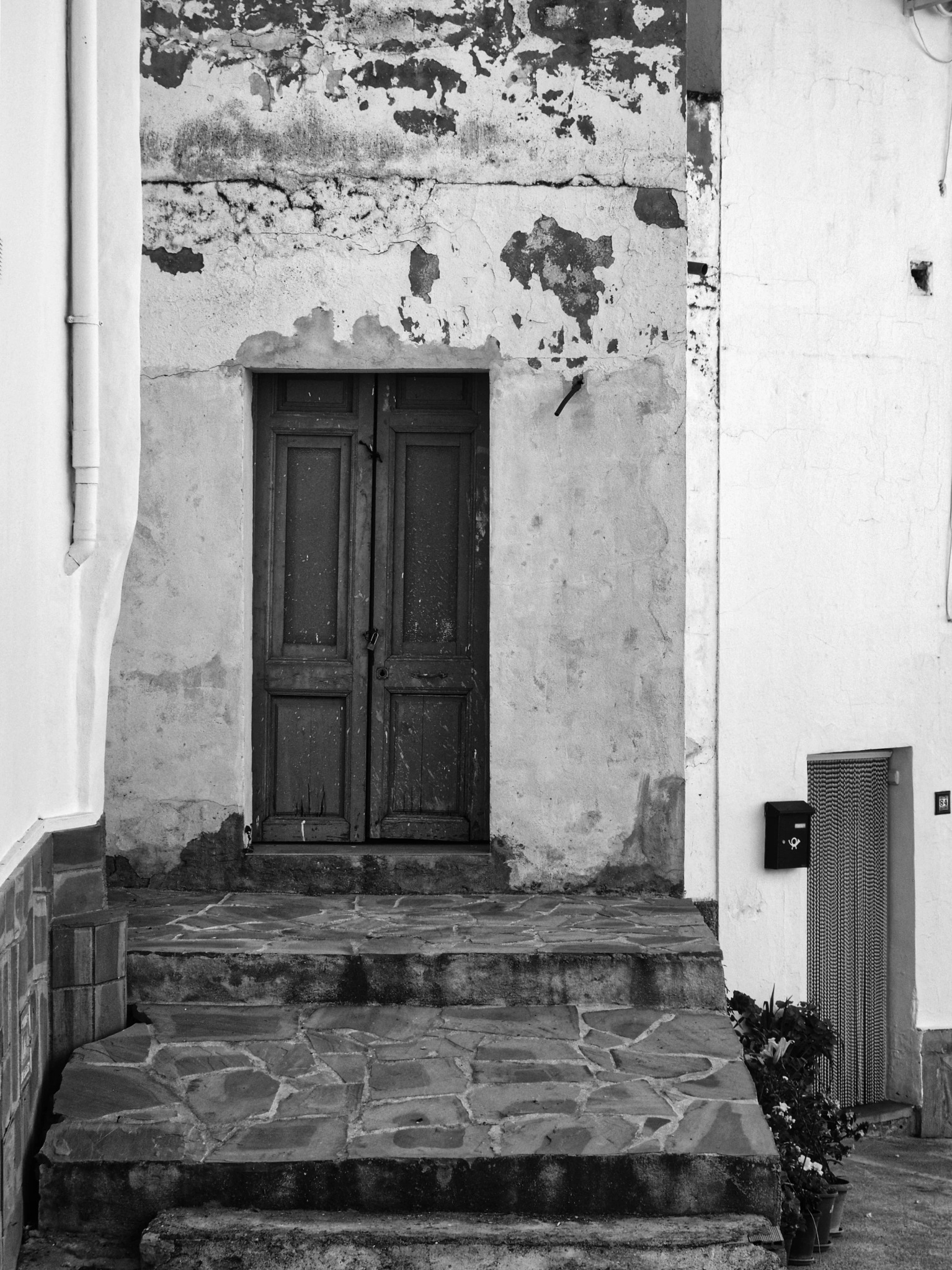 Decayed door peeling render stone steps Casares andalusia village