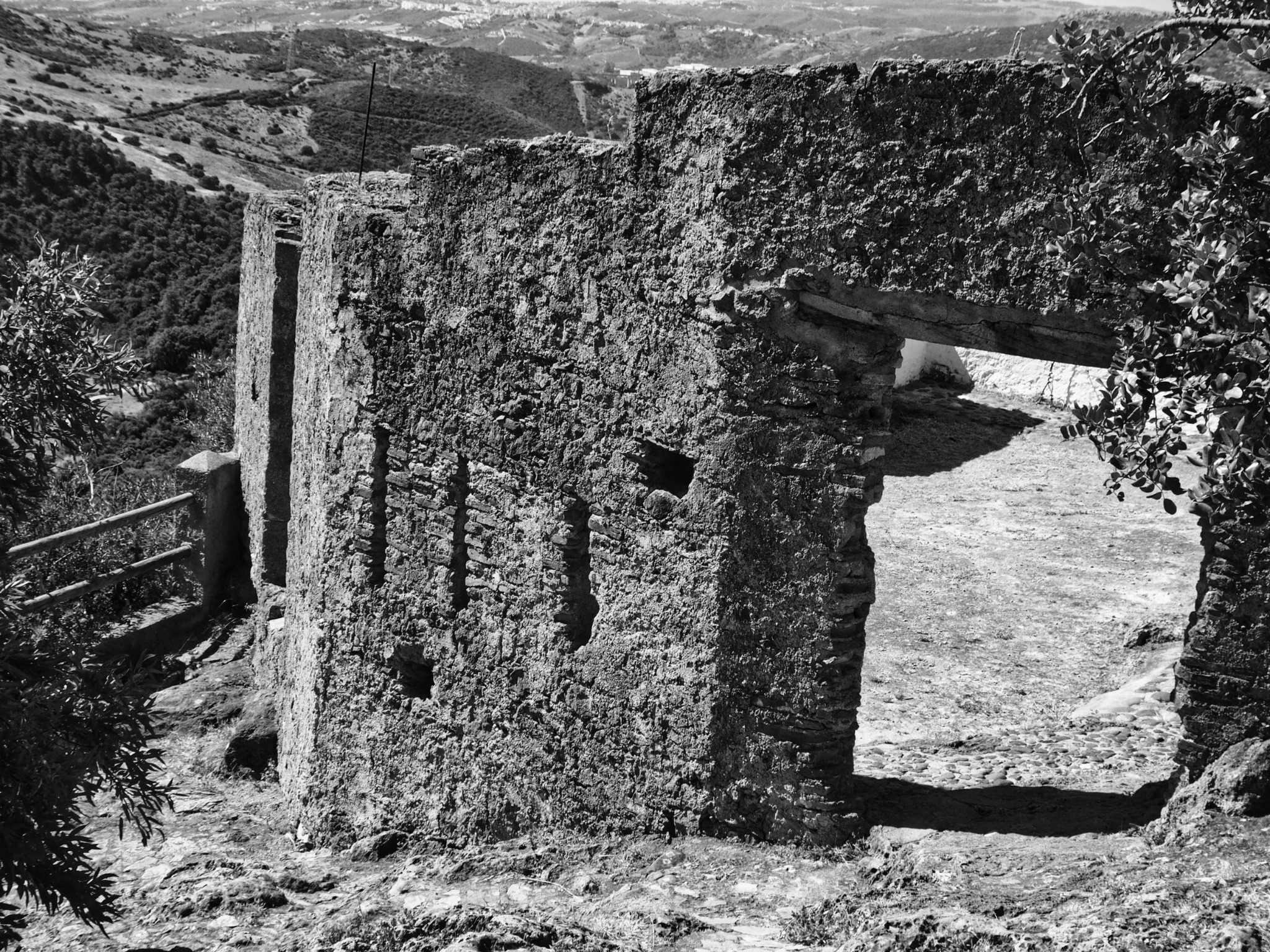 Castle ruin gateway arch rubble hillside andalusia