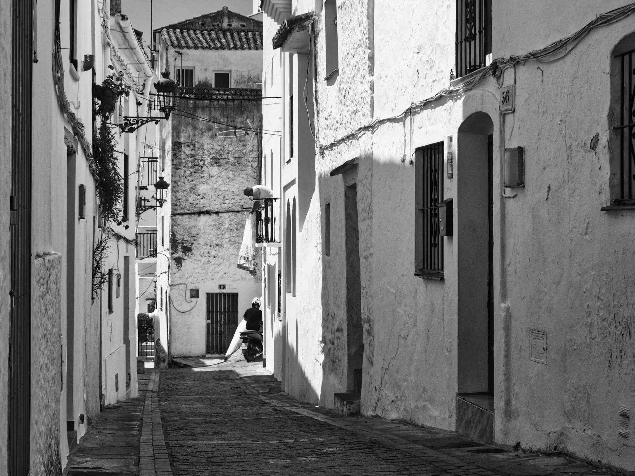 Moped rider dark alley man hanging washing caseras andalusia