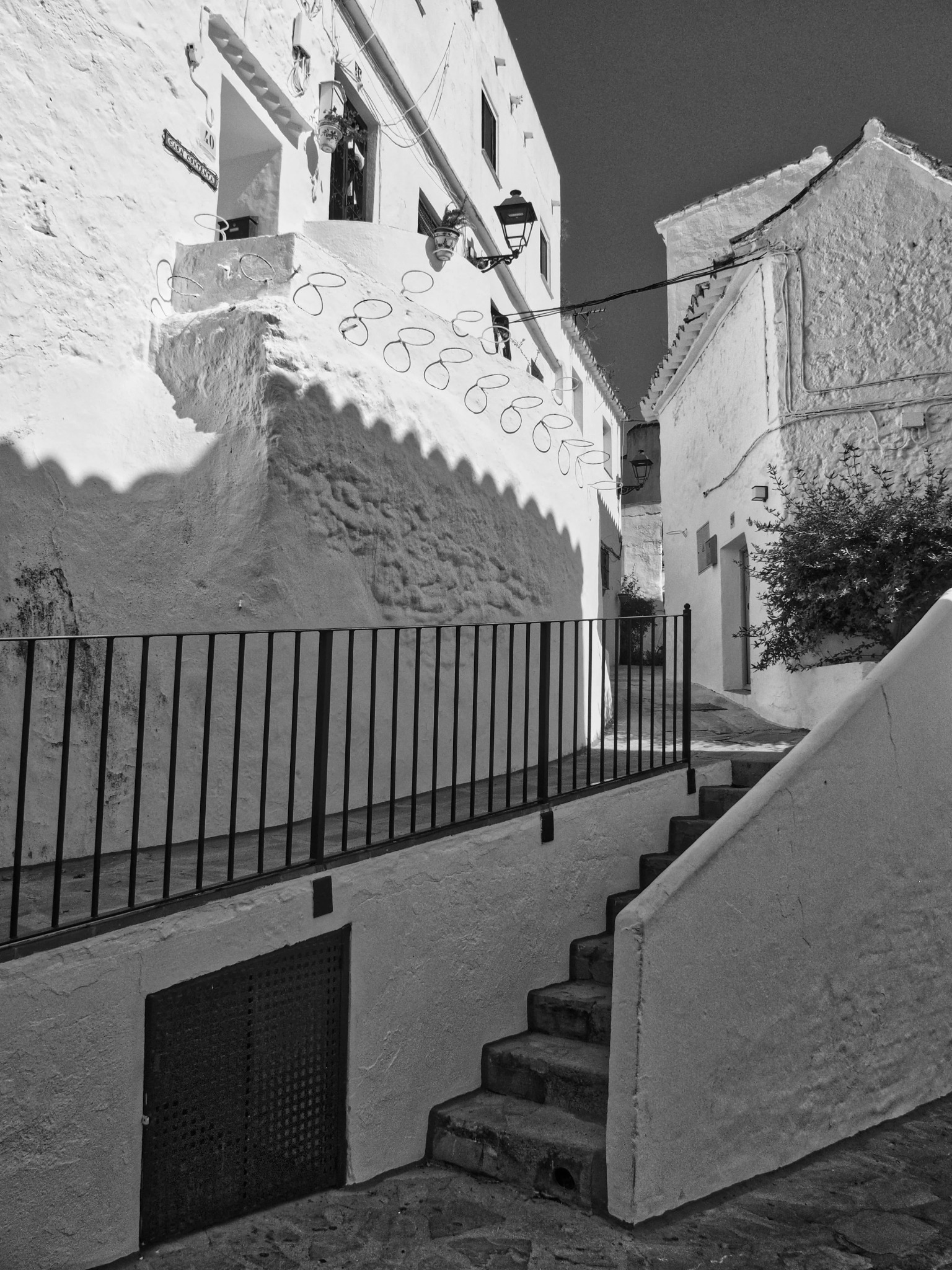 Narrow alley ornate lamp harsh light andalusia village