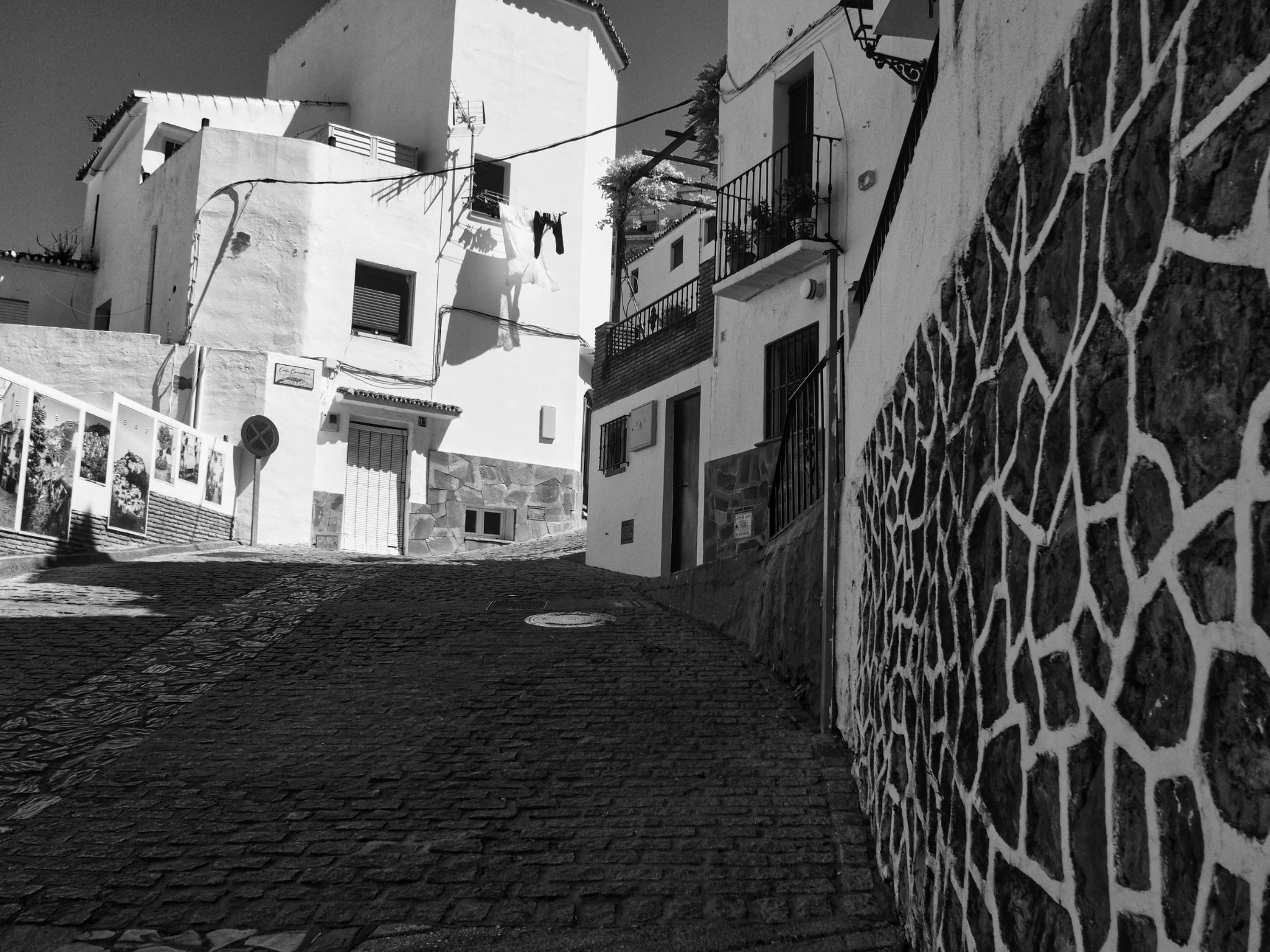 Casares cobbled alley stone wall laundry low angle