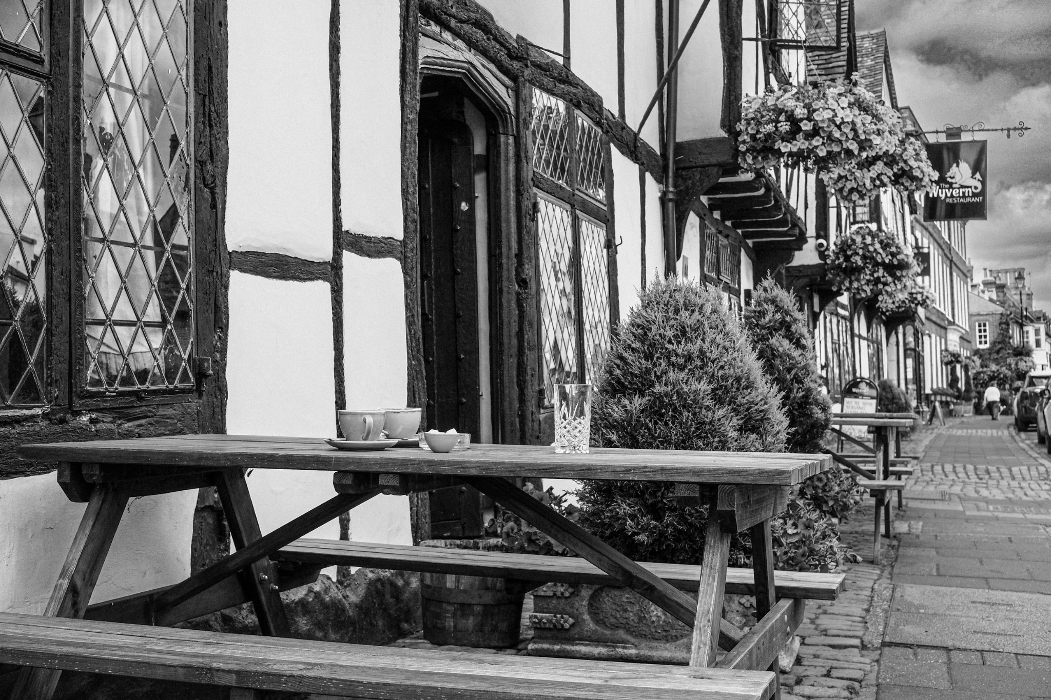 Empty café tables outside a timber-framed building