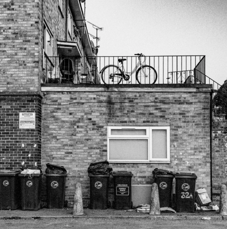 Bicycle and wheelie bins in an urban residential scene